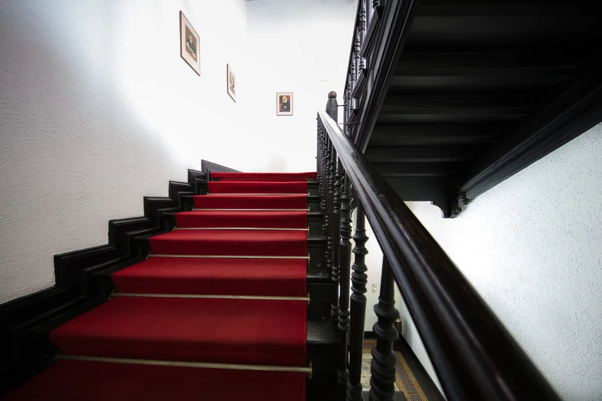 Historisches Treppenhaus mit rotem Läufer in der Gelben Villa